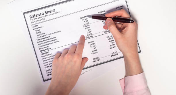 female hands, a brown pen and a balance sheet on a white background. Accounting concept female hands, a brown pen and a balance sheet on a white background. Accounting concept a list of assests stock pictures, royalty-free photos & images